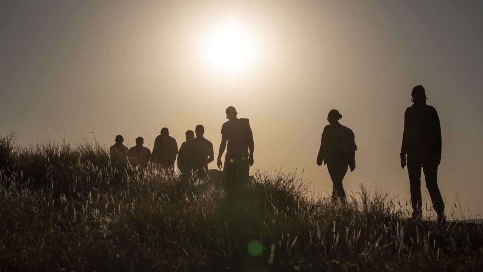 Fusssafari in Afrika: Silhouetten einer Gruppe von Safari-Gaesten auf einer Walking Safari