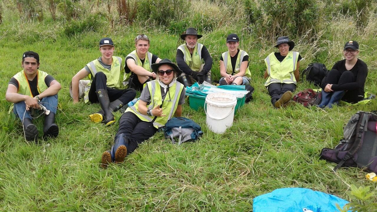 Freiwilligenarbeit in Neuseeland: Mehrere Volunteers legen eine Pause auf einem Feld ein