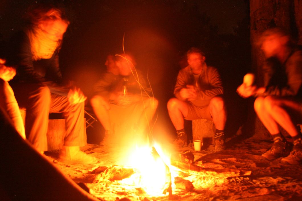 Die Teilnehmer lassen den Tag mit lustigen Gespraechen am Lagerfeuer Revue passieren