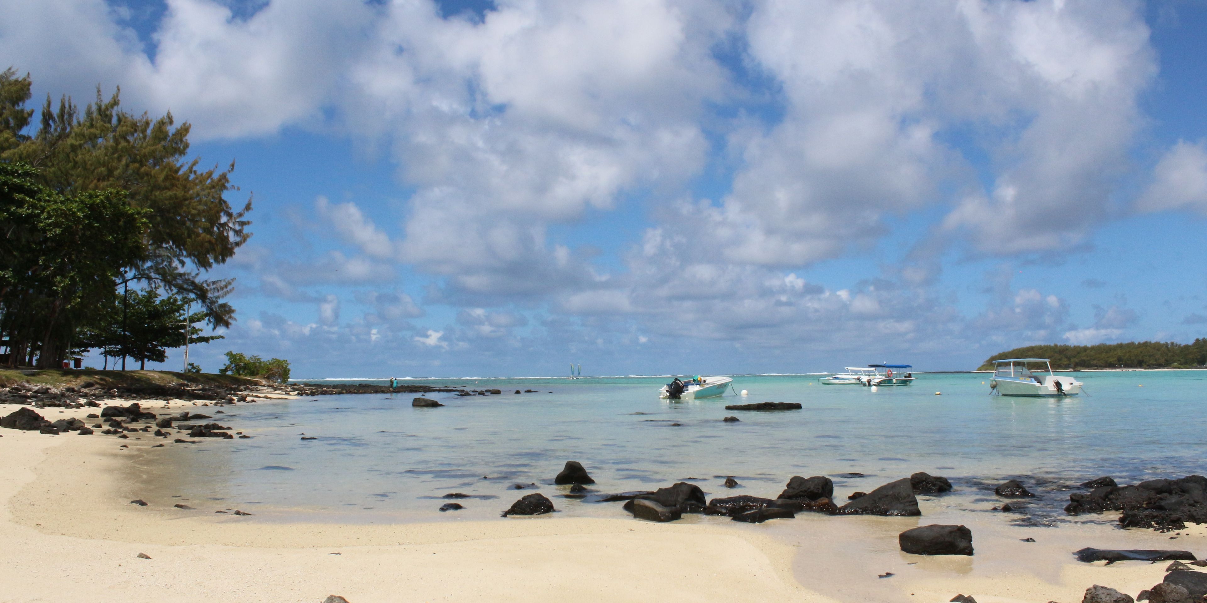 Standing on a beach in Mauritius, looking over the blue Indian Ocean