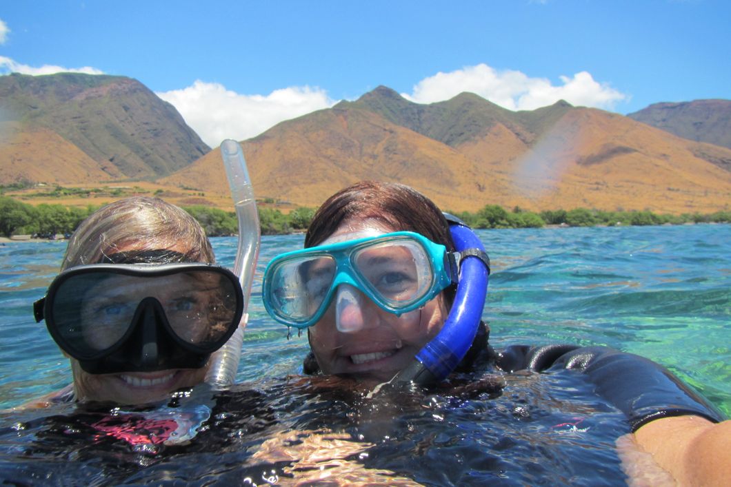 Two volunteers, equipped with snorkel and diving mask, in the waters off the Hawaiian coast