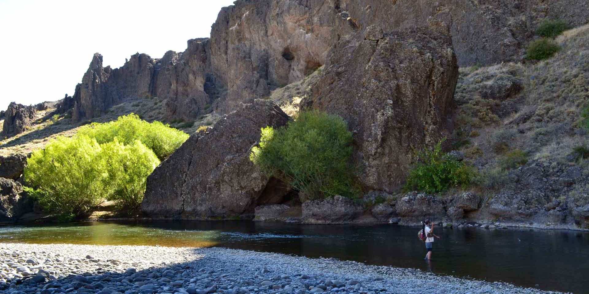 Ein Praktikant angelt in einem Bergfluss in den argentinischen Anden