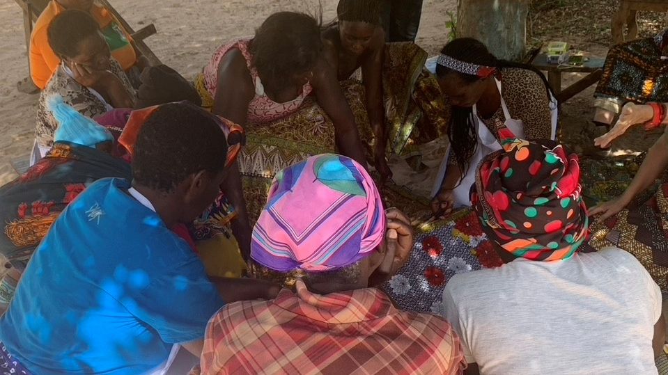 Frauen sitzen in einem Kreis und werden von oben beobachtet