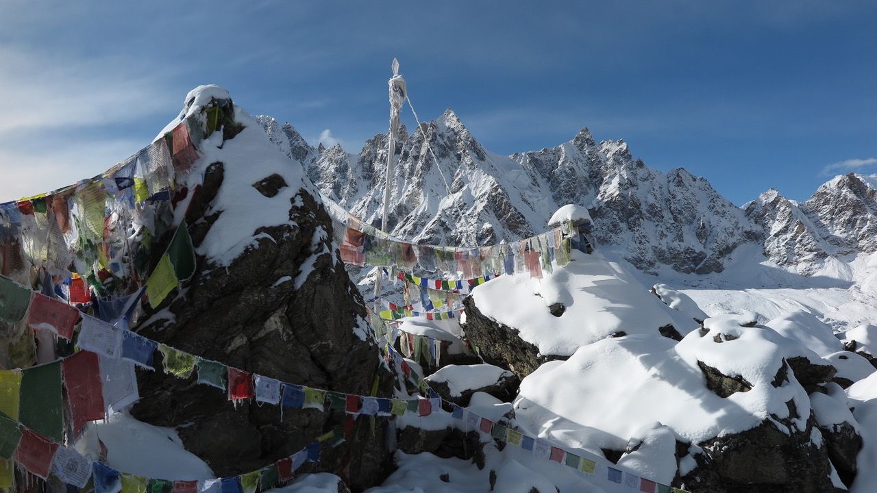 Trekkingtour Nepal: Mit Gebetsfahnen dekorierter Felsabschnitt im Bergmassiv des Himalaya