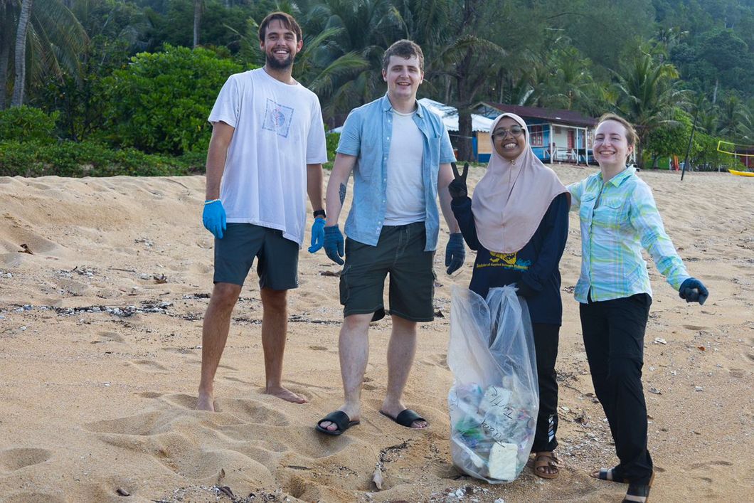 Four people collecting trash
