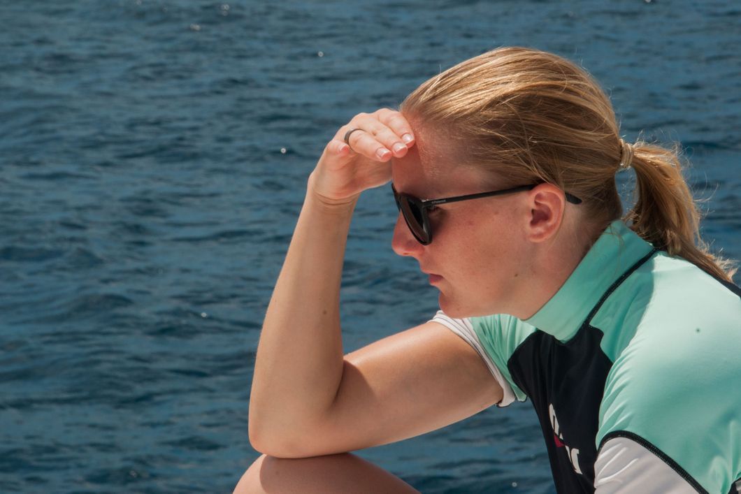 Eine Teilnehmerin der Walhai-Expedition auf den Malediven haelt Ausschau nach Tieren im Wasser