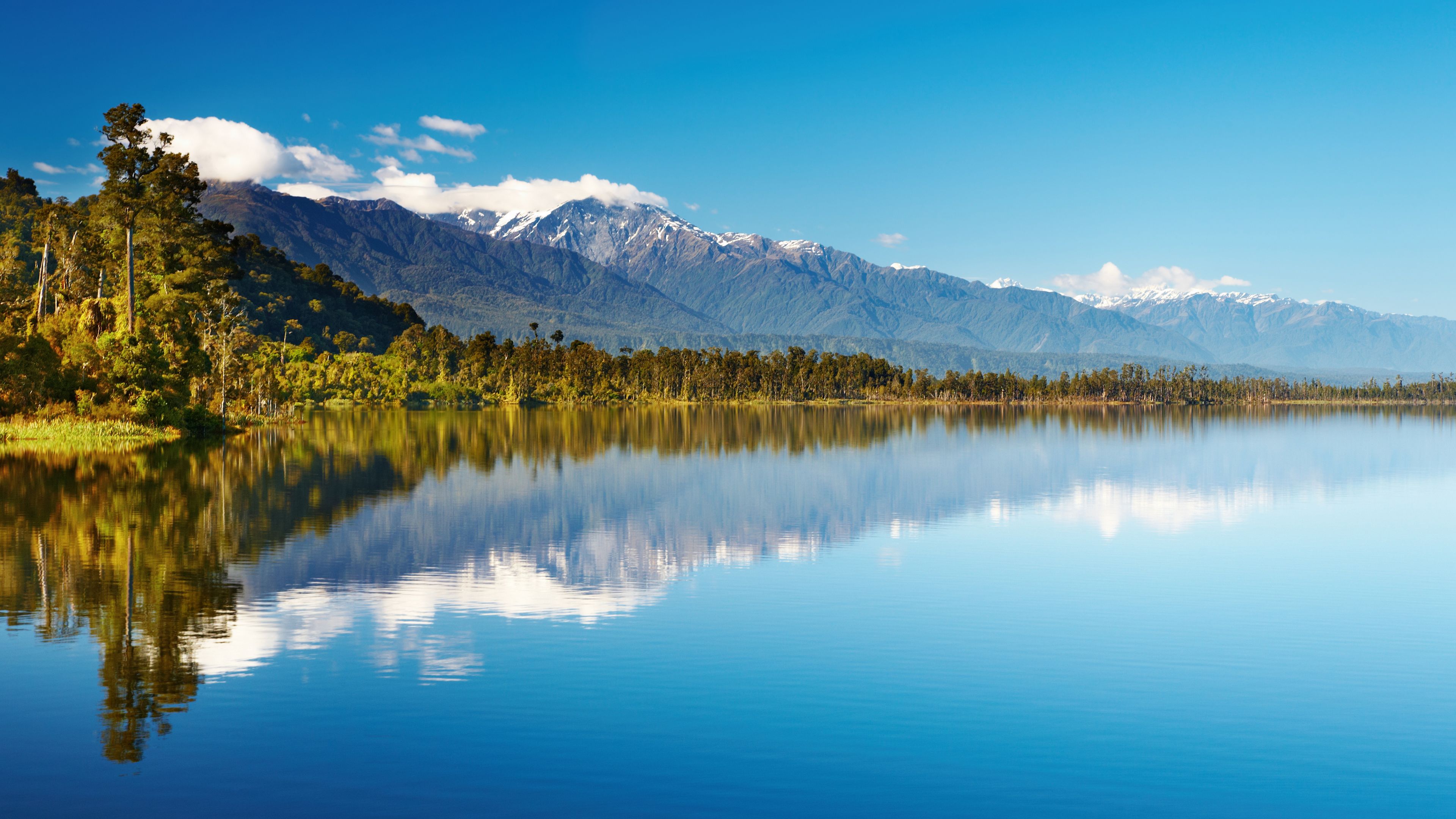 Das Wasser eines Neuseelaendischen Sees ist so klar und Flach das eine optimale Spiegelung der Berge im Hintergrund moeglich ist
