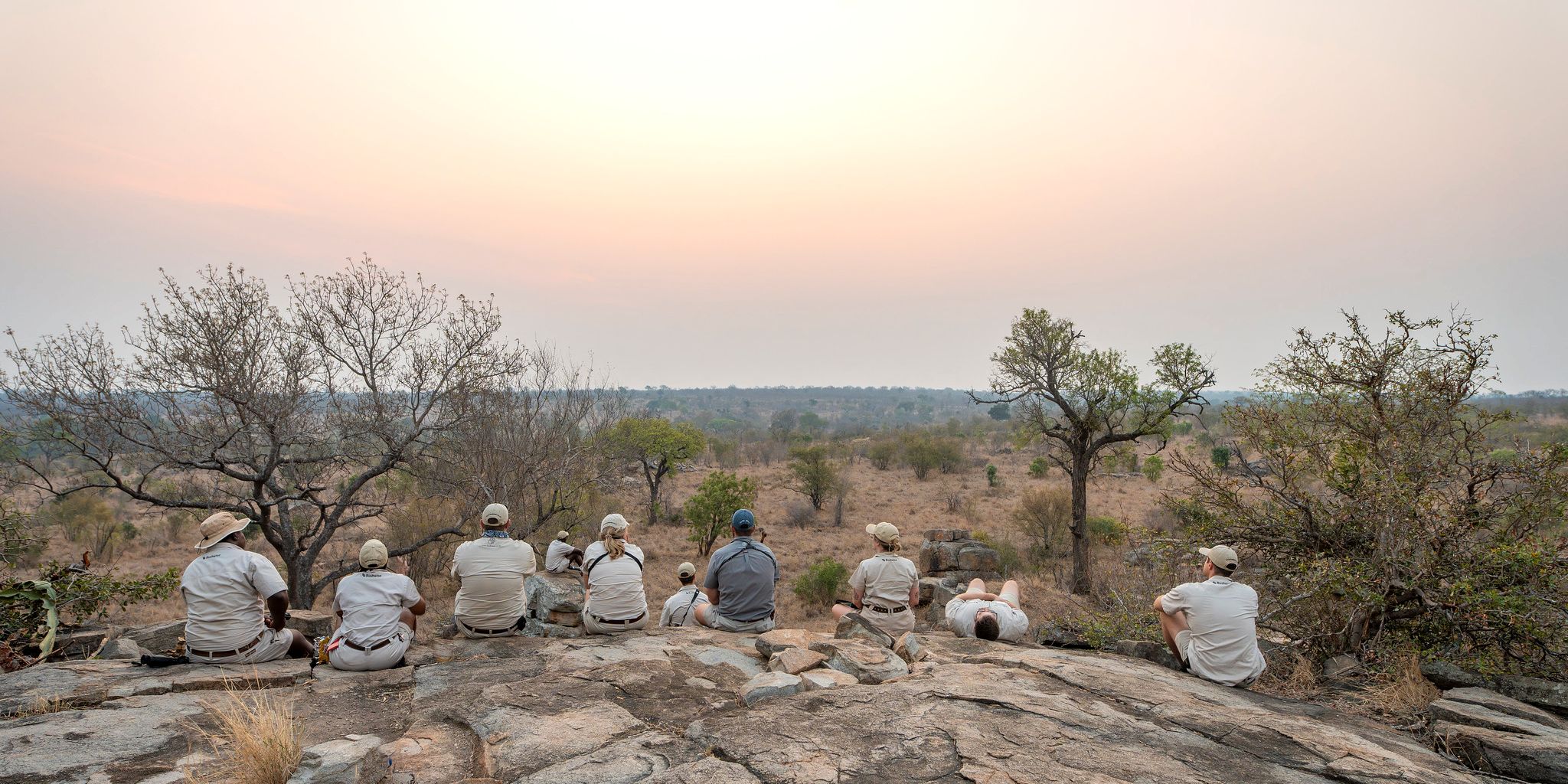 Guppe sitzt auf Felsen mit Blick auf die Landschaft